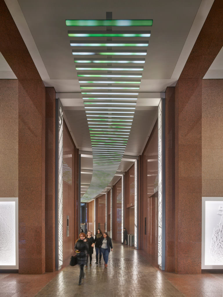 The low-resolution digital ceiling at 85 Broad Street mimics the open sky with leafy green imagery.