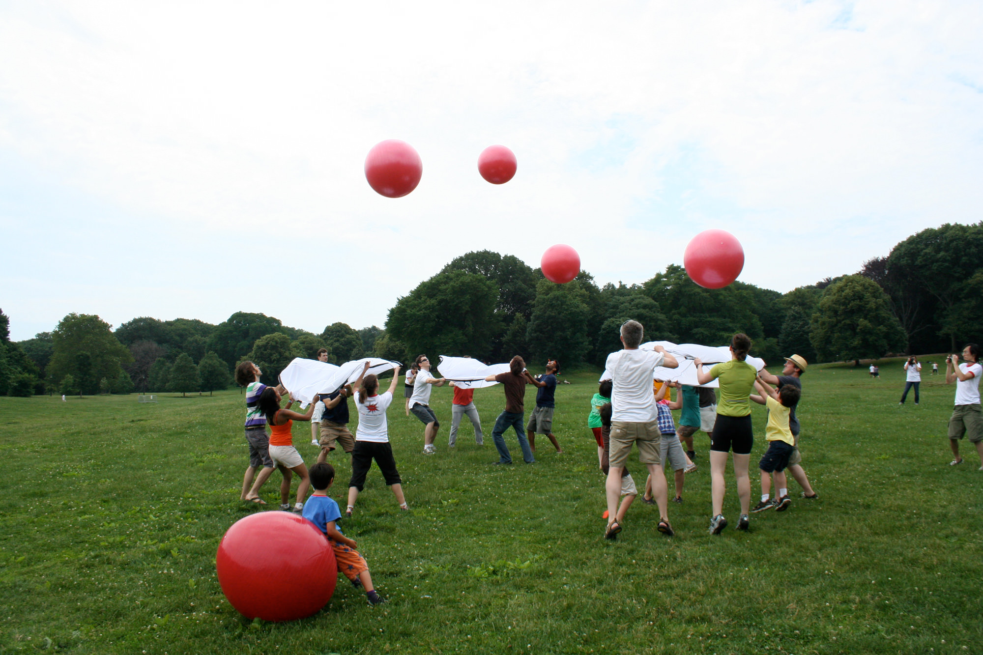 children toss giant balls in a game by ESI Design at the Come Out and ...